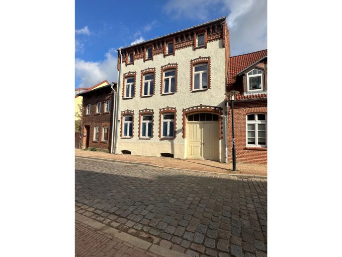Ein Backsteingebäude an einer Kopfsteinpflasterstraße.
